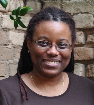 Photo of author, head and shoulders, facing front, wearing glasses, with long locks, smiling at the camera